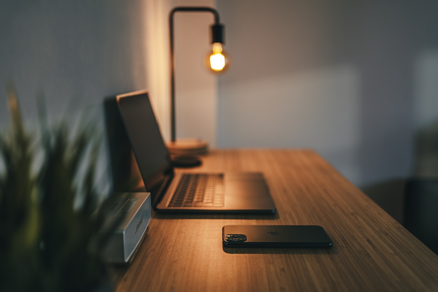 A compact desk setup with a lamp, laptop and tidy surface